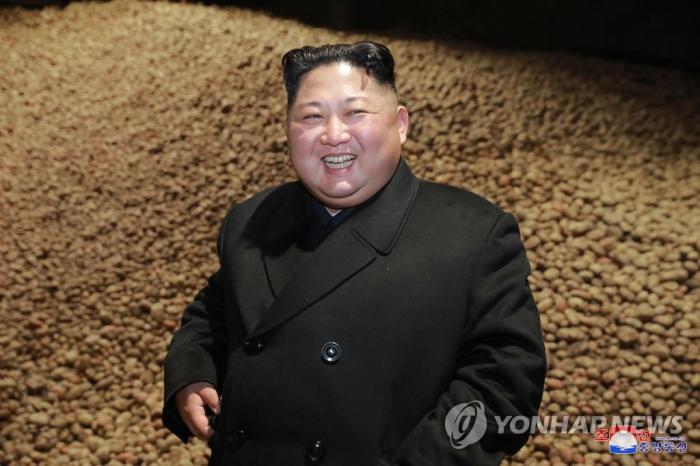 감자 저장고에 가득 쌓인 감자를 배경으로 서 있는 김정은 인터넷 캡쳐